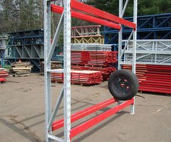 Tire rack with red beams holding a truck tire