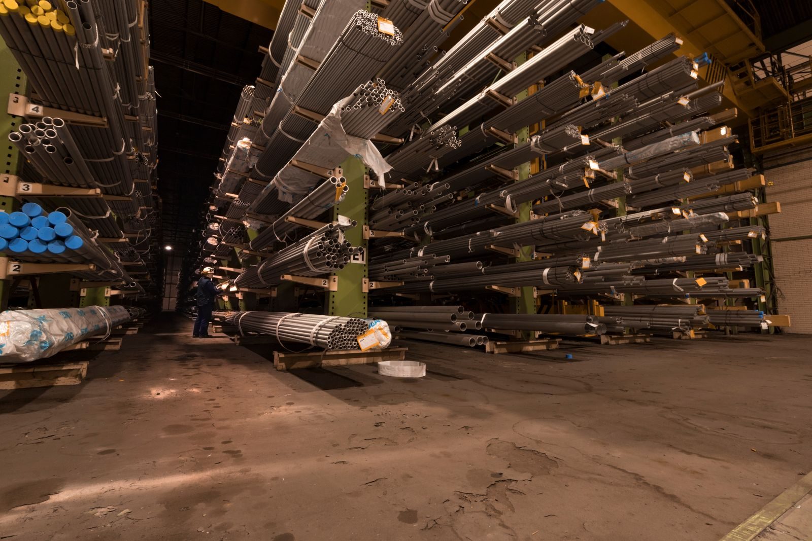 Cantilever racking arms holding steel pipe and bar stock