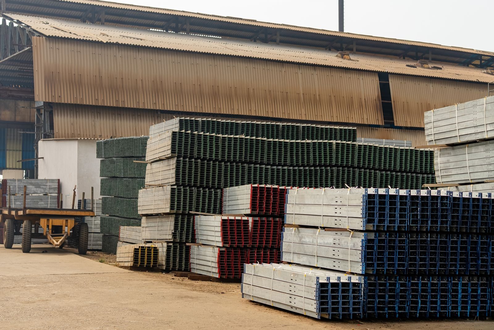 Stacked structural steel beams at an industrial yard